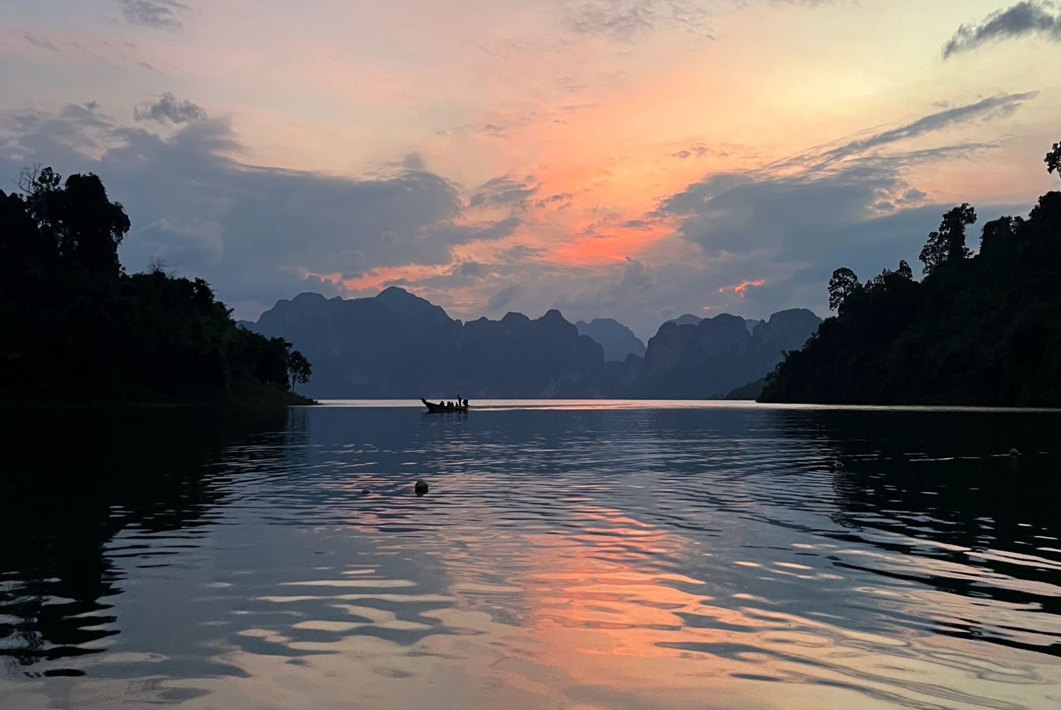 Boat on a lake in the distance just after sunset